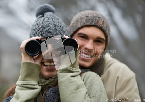 Image of Binoculars, nature and happy couple in portrait for journey, adventure in hiking or carbon footprint travel. Face of young man and woman with outdoor gear for birdwatching in winter, nature or woods