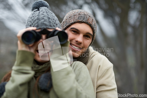 Image of Binoculars, nature and happy couple in forest, journey and adventure in hiking portrait for carbon footprint travel. Face of young man and woman with outdoor gear for birdwatching in winter and woods