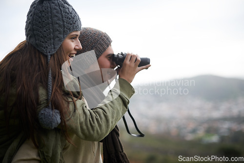 Image of Couple, travel and binoculars on mountains for journey, adventure and hiking or explore together with cityscape. Man and woman trekking with outdoor search, vision or birdwatching lens in tourism