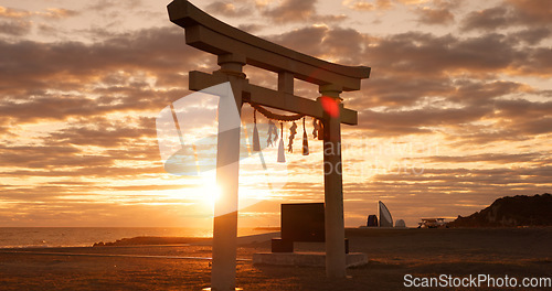 Image of Torii gate, sunset sky and beach in Japan with clouds, zen and spiritual history on travel adventure. Shinto architecture, Asian culture and calm nature on Japanese landscape with sacred monument.