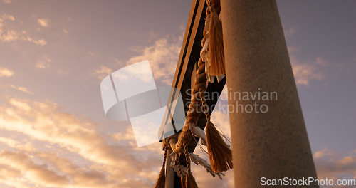 Image of Torii gate, sunset and sky in Japan with clouds, zen and spiritual history on travel adventure. Shinto architecture, Asian culture and calm nature on Japanese landscape with sacred monument at shrine