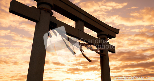 Image of Torii gate, sunset and cloudy sky with zen, peace and spiritual history on travel adventure in Japan. Shinto architecture, Asian culture and calm nature on Japanese landscape with sacred monument.