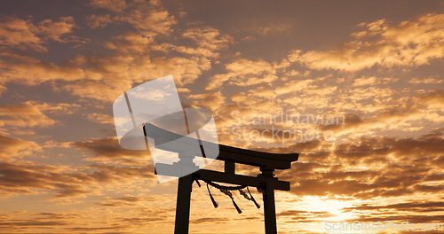 Image of Torii gate, sunset sky in Japan with nature, zen and spiritual history on travel adventure. Shinto architecture, Asian culture and calm clouds on Japanese landscape with sacred monument at shrine.