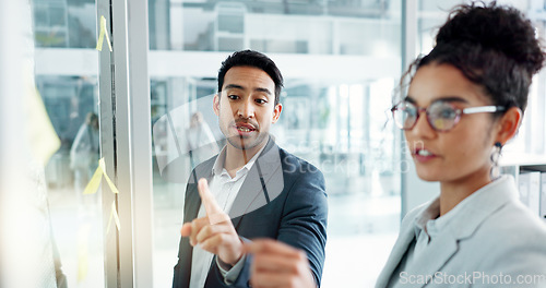 Image of Business man, woman and planning by glass board, point and talk with thinking, notes and problem solving. Corporate partnership, brainstorming and discussion with moodboard, decision and solution