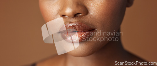 Image of Closeup, lips and black woman with beauty, smile and skincare on a brown studio background. African person, girl and model with gloss, cosmetics and dermatology with clear skin, smooth and aesthetic
