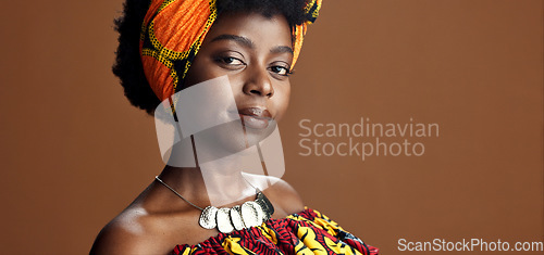 Image of Culture, African fashion or face of black woman in studio on a brown background for trendy style. Unique, beauty or model with confidence, pride or afro posing in wrap, clothes or traditional outfit