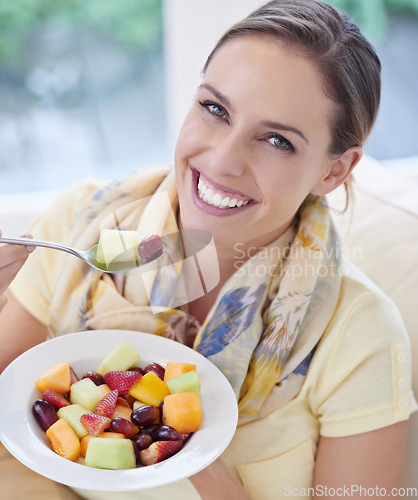 Image of Healthy food, woman in portrait with fruit in salad and diet, organic breakfast and relax on sofa with smile for weight loss. Vegan meal, gut health and wellness, eating for nutrition with vitamins