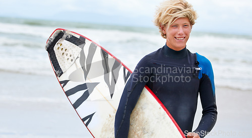 Image of Surfer, boy and happy on beach with surfboard, vacation and adventure for fitness and travel. Ocean, waves for surfing and teen on seaside holiday in Hawaii, nature and tourism with extreme sports