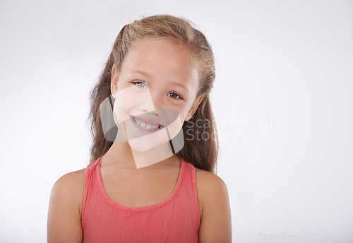 Image of Child, girl and portrait or smile in studio with confidence, positive attitude and carefree youth. Kid, face and happiness with calm expression, mock up space and casual outfit on white background