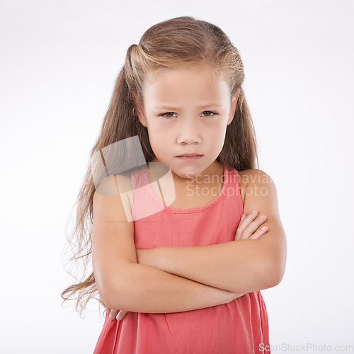 Image of Portrait, unhappy and girl child arms crossed in studio on white background with anger and frustration. Problem, tantrum or moody and young kid with bad attitude looking upset at mistake or error