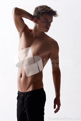 Image of Topless, natural and masculine with body of man in studio on white background for health or wellness. Aesthetic, skin or stomach and young shirtless model in jeans for hygiene and satisfaction