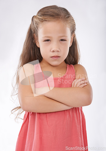 Image of Angry, girl and child in studio with arms crossed, frustrated in portrait and emotion, cross or upset on white background. Facial expression, rage and conflict with tantrum, furious and bad attitude