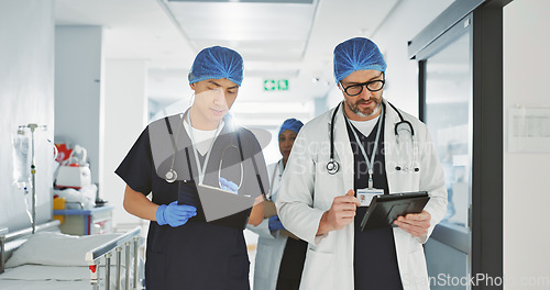 Image of Teamwork, talking and doctors with a tablet at a hospital for health advice or surgery communication. Help, clinic and medical employees speaking with technology, planning and schedule for nursing