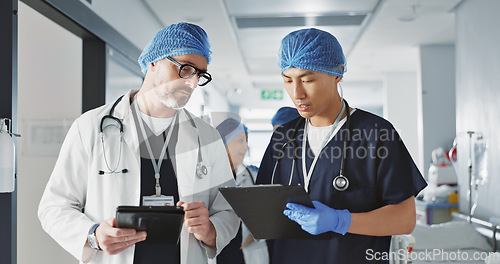 Image of Teamwork, talking and doctors with a tablet at a hospital for health advice or surgery communication. Help, clinic and medical employees speaking with technology, planning and schedule for nursing