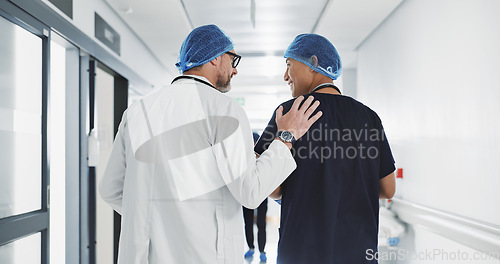 Image of Doctor, nurse and talk while walk in hospital with advice, consult or communication with medical team. People, discuss or coaching for patient care, treatment and wellness after surgery with joke