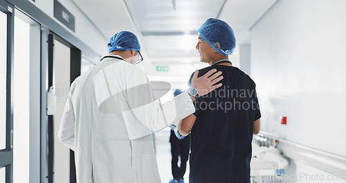 Image of Doctor, nurse and talk while walk in hospital with advice, consult or communication with medical team. People, discuss or coaching for patient care, treatment and wellness after surgery with joke