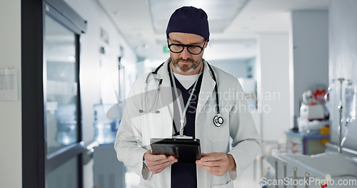 Image of Hospital, doctor and man with a tablet, typing and healthcare with email, consultant and website info. Mature person, employee and medical professional with technology, search internet and surgeon