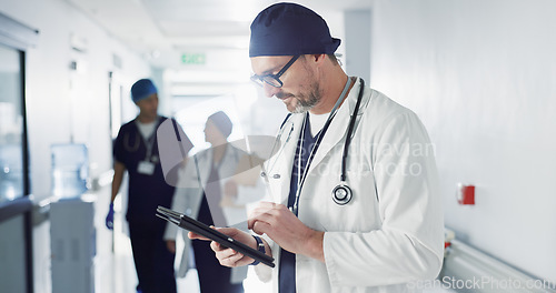 Image of Man, doctor and tablet for hospital, healthcare or clinic research, online planning and schedule management. Medical professional or surgeon typing on digital technology for surgery results or data