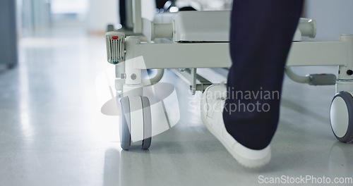 Image of Healthcare, doctor and push bed in hospital for surgery, emergency or medical problem in corridor. Medicine, professional and nurse feet with stretcher for wellness, service and risk in clinic or job