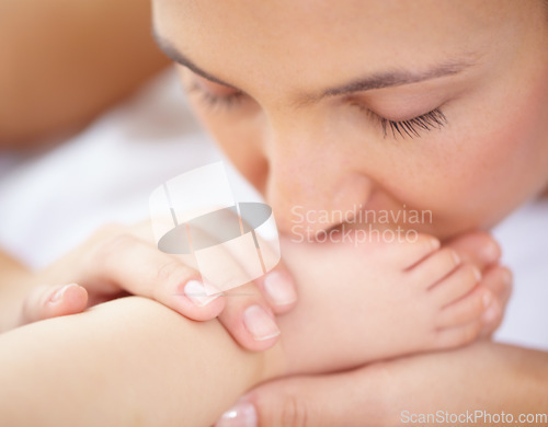 Image of Mom, baby and kiss feet of child for love, care and relax in nursery room at home. Face, mother and closeup of foot of young kid for newborn development, healthy childhood growth or affection of bond