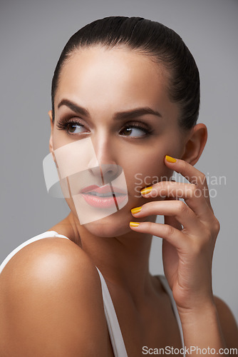 Image of Woman, face and manicure with lipstick for beauty, yellow nail polish and cosmetics on grey background. Cosmetology, orange lips and hand with color nails, confident in makeup and glamour in studio