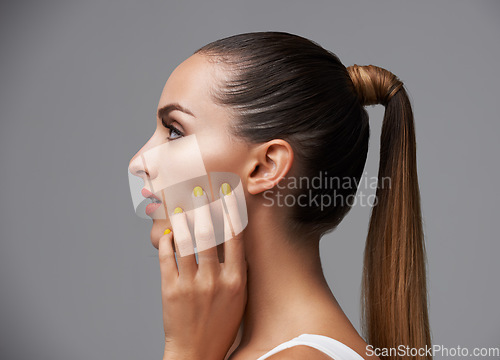 Image of Manicure, face and profile of woman in makeup, beauty and cosmetics with nails and hair care on grey background. Hand, yellow nail polish and lipstick with skin, glamour and shiny ponytail in studio