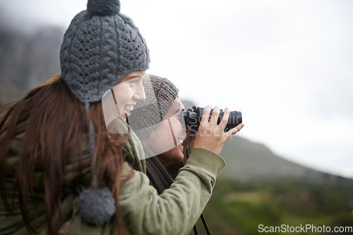 Image of Couple, travel and binoculars on mountains for journey, adventure and hiking or explore together in winter. Happy man and woman trekking with outdoor search, vision or birdwatching lens in nature