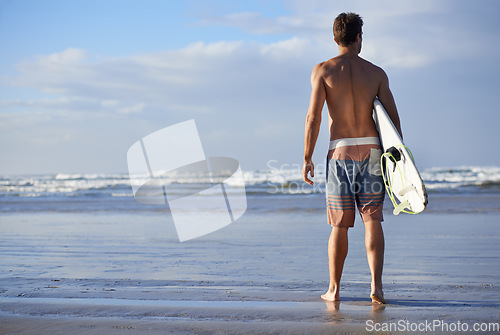 Image of Surfing, fitness and back of man at a beach with surfboard for freedom, travel or sports outdoor. Ocean, training and male surfer at the sea for swimming, wellness or adventure, workout or holiday