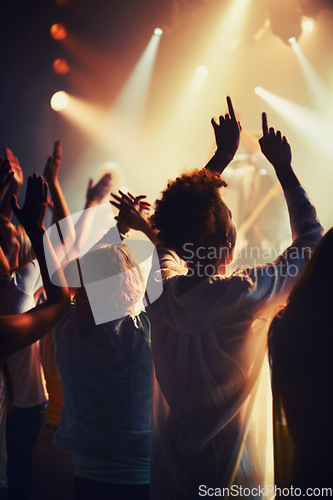 Image of Concert, fans and people dance to music, event and lights on stage for performance at festival. Nightclub, party and back of audience or excited crowd listening to musician and sound with freedom