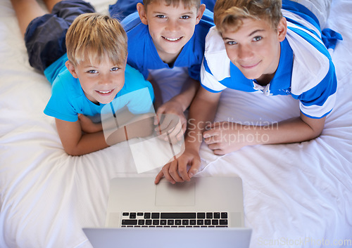 Image of Brothers, home and playing on laptop in bedroom, above and excited for online games in house. Young children, mousepad and streaming cartoons on bed for bonding together, love and relax on weekend