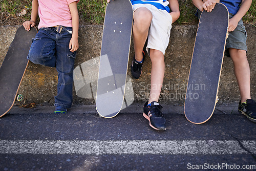 Image of Kids, friends and skateboard for outdoor relax or exercise sneakers for workout, balance or city street. People, legs and neighbourhood wall rest or fitness on road or transport, practice or urban