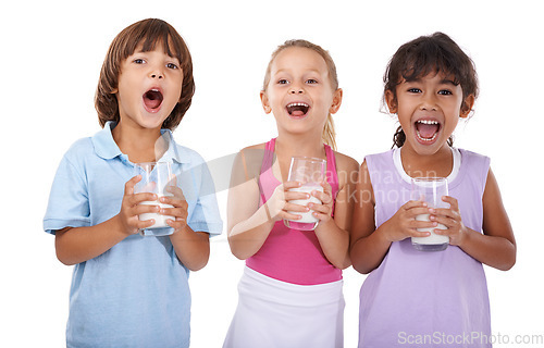 Image of Happy, children and portrait with milk in glasses for nutrition, health and energy in white background of studio. Calcium, drink and kids smile with dairy, protein and benefits in diet for growth