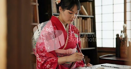 Image of Calligraphy, writing and traditional Japanese woman in home for script, paper and documents. Creative, Asian culture and person with vintage paintbrush, ink and tools for art, font and text in house