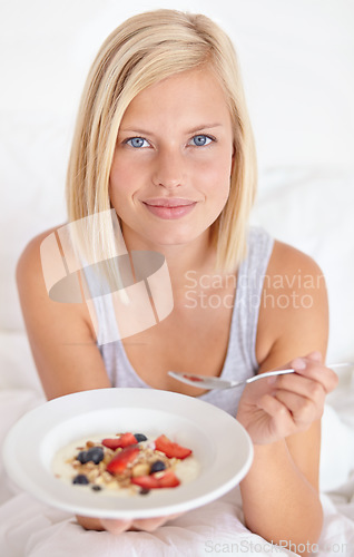 Image of Breakfast, portrait and woman in a bed with muesli, meal or berries for balance, wellness or gut health at home. Fruit, eating or female person face in bedroom for diet, nutrition or superfoods snack