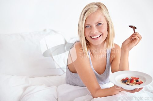 Image of Woman, portrait and breakfast in bedroom, hotel and wake up for morning hospitality or accommodation. Relax, cereal or holiday with happy young person in bed of home, weekend or comfortable with food