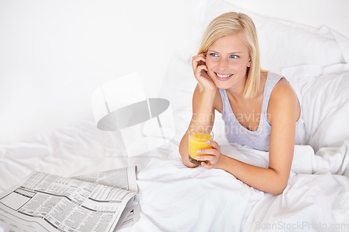 Image of Smile, thinking and juice with woman in bed of hotel to wake up for morning hospitality or accommodation. Relax, newspaper and vacation with happy young blonde person in bedroom of home on weekend