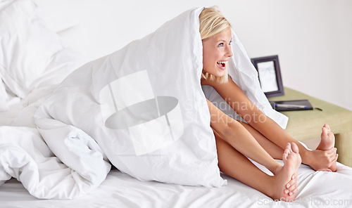 Image of Morning, stretch and happy woman in a bed with blanket, smile or waking up playful in her home. Refreshed, energy and cute female person stretching body in a bedroom ready, awake and fun in a house