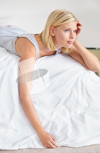 Image of Relax, thinking and woman in bedroom of hotel on weekend for luxury hospitality or accommodation. Home, vision and morning wake up with cozy young blonde person lying on bed of guest house apartment