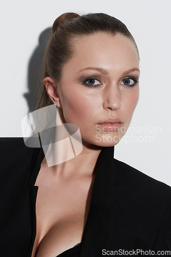 Image of Portrait, style and beauty of serious woman in studio isolated on a white background. Face, makeup and young model or person in cosmetics, fashion blazer and trendy clothes on a backdrop in Spain