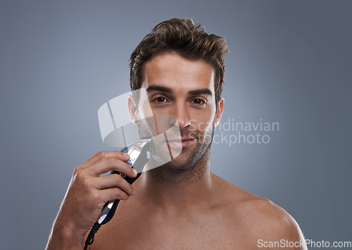 Image of Man, electric shaver and studio portrait for grooming, skincare and happy for wellness by grey background. Person, model and beard with hygiene, facial hair removal and product for cosmetic change