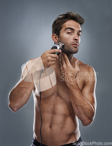 Image of Man, portrait and electric razor in studio for beard maintenance, hair removal or grey background. Male person, shirtless and tools for cleaning skin or hygiene car for confidence, health or mockup