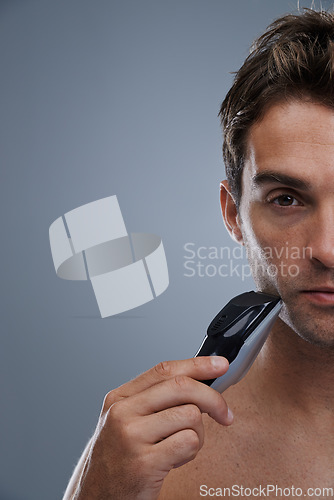 Image of Man, electric shaver and grooming with closeup studio portrait, space and mockup by grey background. Person, model and shaving beard with hygiene, facial hair removal or product for cosmetic change