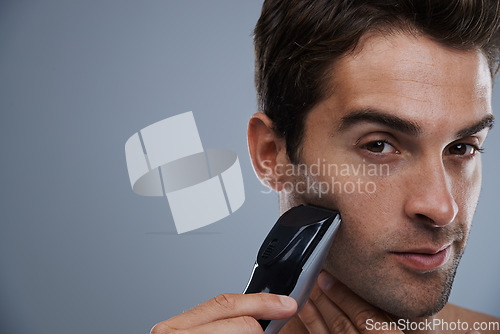 Image of Man, portrait and electric razor for shaving beard or maintenance, hair removal or grey background. Male person, shirtless and tools for cleaning skin or hygiene car for confidence, studio or mockup