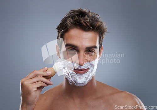 Image of Man, portrait and shaving cream with brush studio application for healthy skin, hygiene or confidence. Male person, face and beard or fresh hair removal as maintenance care, grey background or mockup