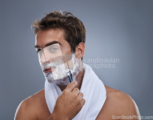 Image of Man, razor and shaving cream in studio portrait for grooming, skincare and wellness by grey background. Person, model and beard with hygiene, facial hair removal and foam product for cosmetic change