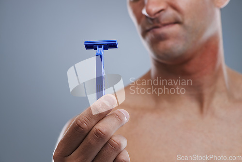 Image of Grooming, man and razor with routine, closeup and cleaning on a grey studio background. Person, hand and model with tool, cosmetics and treatment with dermatology and equipment with hair removal