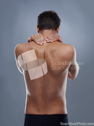 Image of Man, neck pain and spine problem in studio, medical crisis and muscle tension or injury of training. Model, joint ache and back with inflammation of sport accident and arthritis by grey background