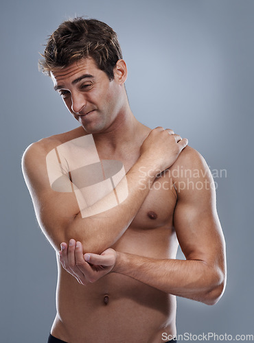 Image of Arm, pain and man with elbow injury, medical emergency and massage tender osteoarthritis risk. Arthritis, osteoporosis and studio person with bone problem, accident or hurt anatomy on grey background
