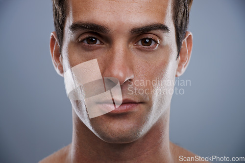 Image of Portrait, skincare and man with dermatology, wellness and confident guy on grey studio background. Face, person and model with beauty and grooming with routine and cosmetics with glow and aesthetic