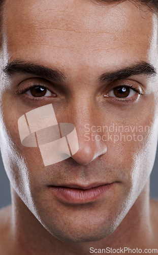 Image of Portrait, skincare and man with cosmetics, closeup and dermatology on grey studio background. Face, person or model with beauty or grooming with routine or wellness with glow, aesthetic and self care